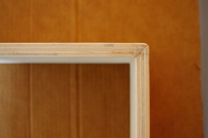 Dettaglio dell'incollatura a 45° delle parti del ripiano, in legno compensato.